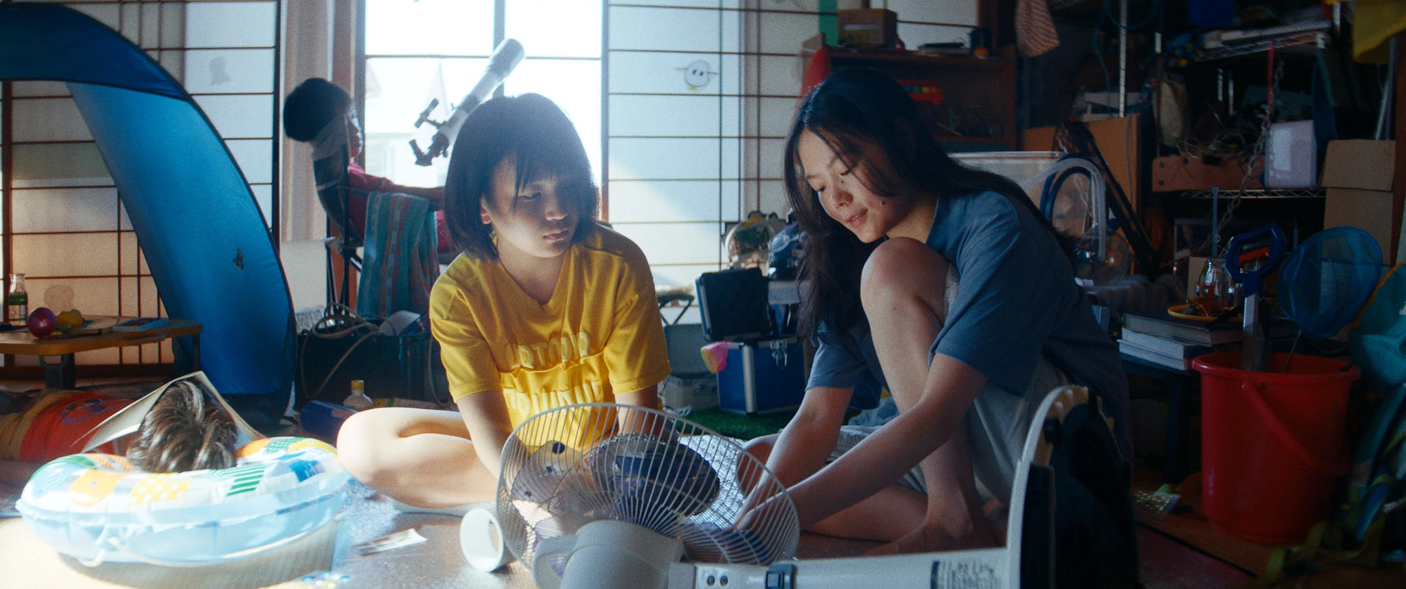 部屋で扇風機を囲む二人